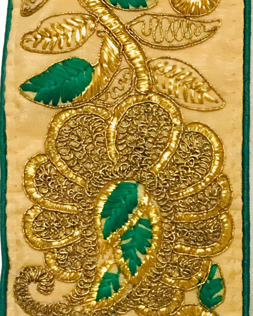 Couronne Dorée présentée sur un tissu blanc, avec motifs floraux dorés et détails verts