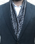 Écharpe noire à motifs jacquard blancs portée avec un costume