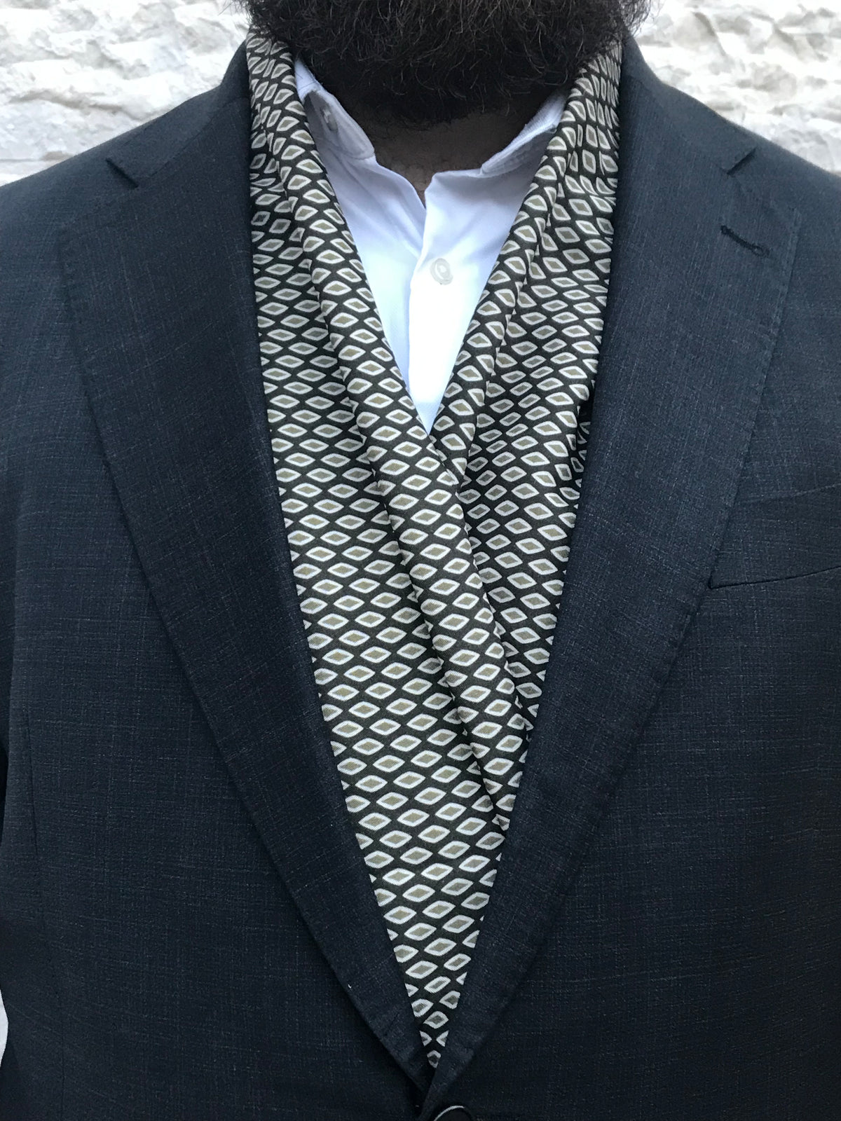 Écharpe verte à motifs géométriques en losanges portée avec un costume